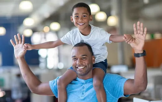 a person carrying a child on the shoulders