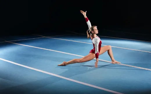 a woman doing a handstand on a blue mat