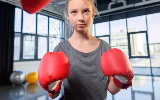 a woman holding a large red boxing glove