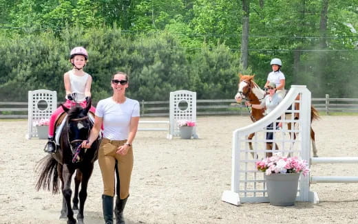 a woman riding a horse next to a man and a woman