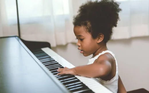 a young girl playing a piano
