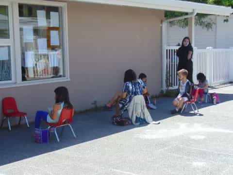 a group of people sitting outside a house