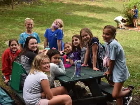 a group of people sitting around a table outside