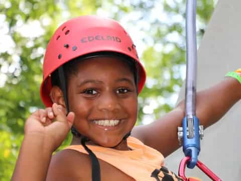 a young girl wearing a helmet and holding a pole