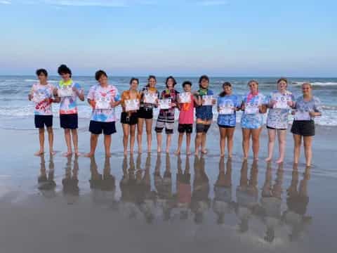 a group of people standing on a beach