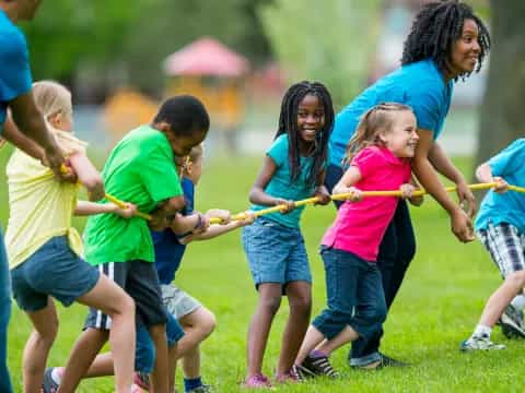 a group of children playing with a rope