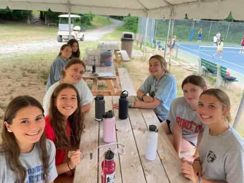 a group of people sitting at a table outside