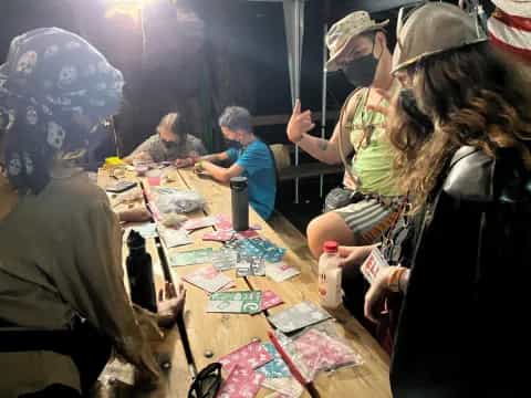 a group of people sitting at a table with a person standing in front of them