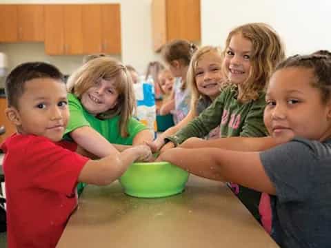 a group of children sitting at a table