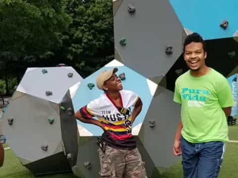 a couple of men posing for a picture next to a couple of white satellites