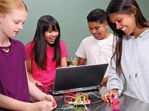 a group of people looking at a laptop