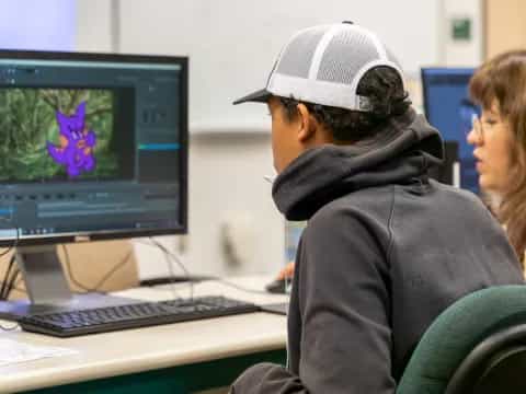 a man and woman looking at a computer screen