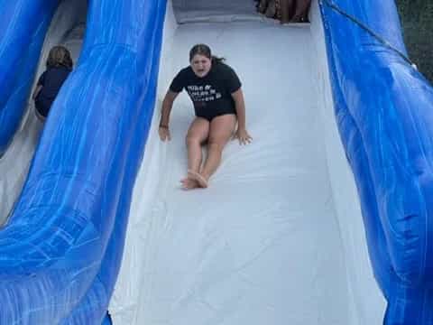 a person sitting in a large blue tent