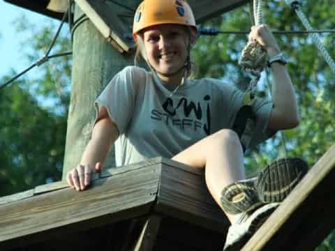 a person wearing a helmet and climbing a rope