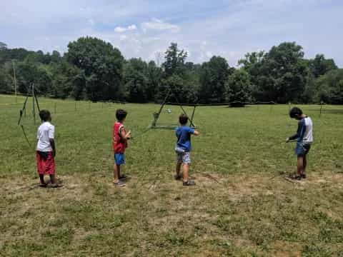 a group of kids playing with a kite