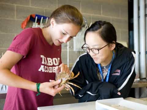 a person showing a girl something on the paper