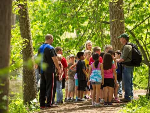 a group of people standing in a forest