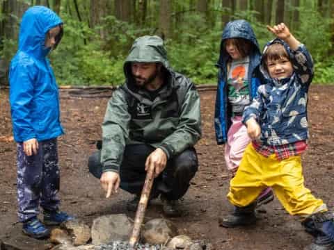 a person and two children standing next to a fire