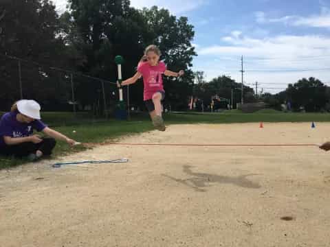 a girl jumping in the air with a ball in her hand