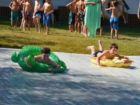 two boys lying on a mat in front of a group of people