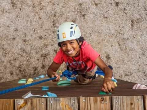 a person wearing a helmet and climbing a wooden structure