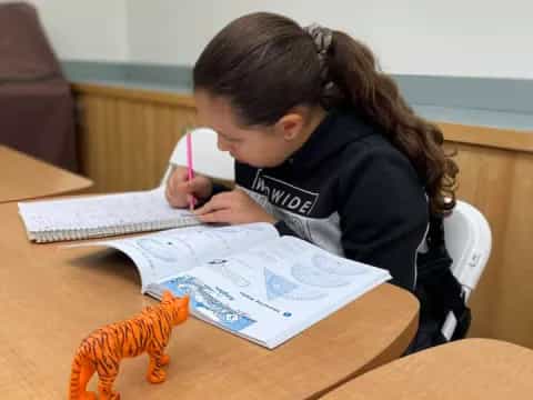 a girl writing on a piece of paper