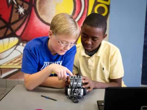 a couple of boys looking at a toy car