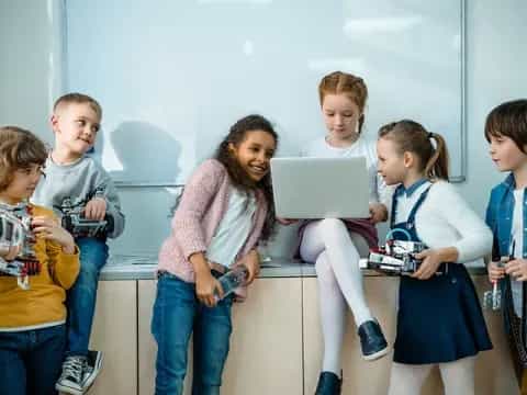 a group of children looking at a laptop