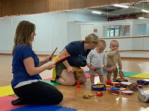 a person and two children playing with toys in a room