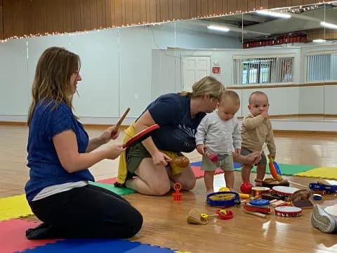 a person and two children playing with toys in a room