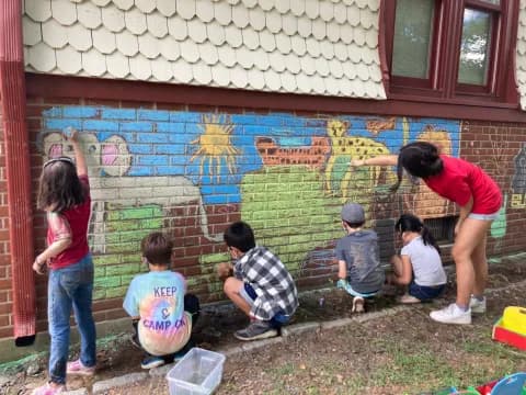 a group of people painting on a wall