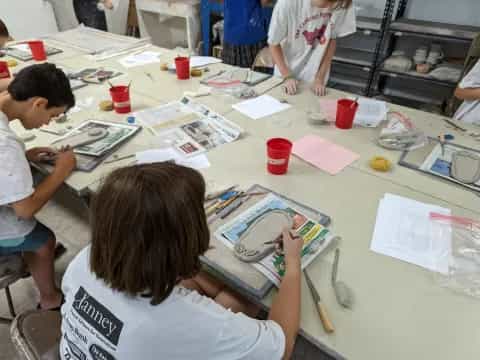 a group of people sitting at a table with papers and books