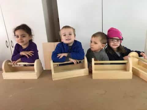 a group of children sitting in a wooden box