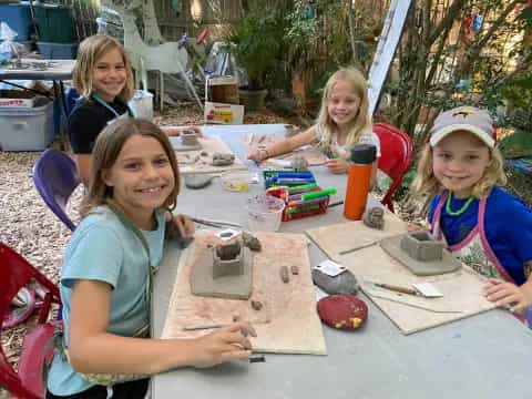 a group of girls sitting at a table with food and drinks