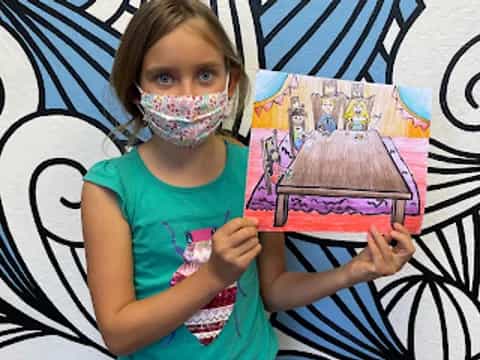 a girl holding a drawing