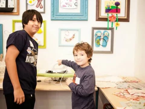 a boy and a girl in a room with art on the wall