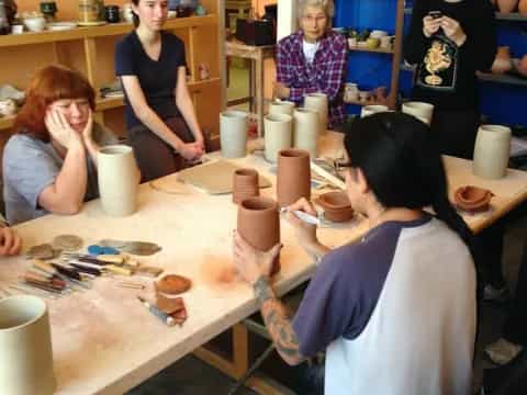 a group of people sitting around a table with cups on it