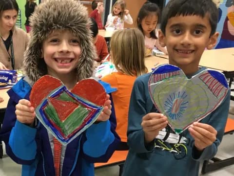 a couple of children holding up a blue and red flag