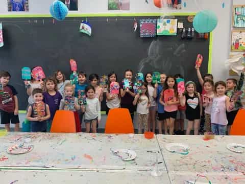 a group of children posing for a photo in front of a chalkboard