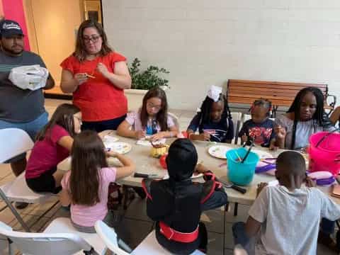 a group of children sitting around a table eating