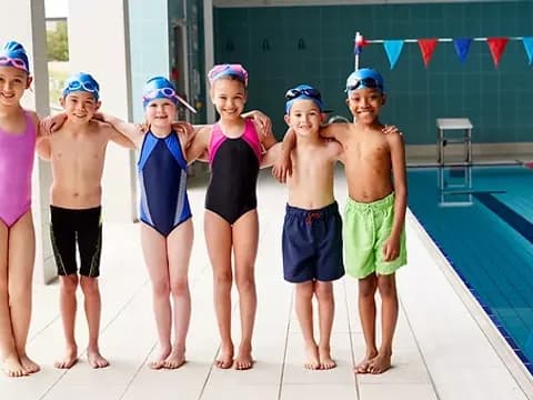a group of people posing for a photo by a pool