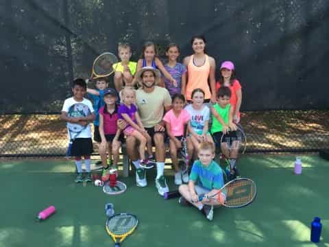 a group of kids holding tennis rackets