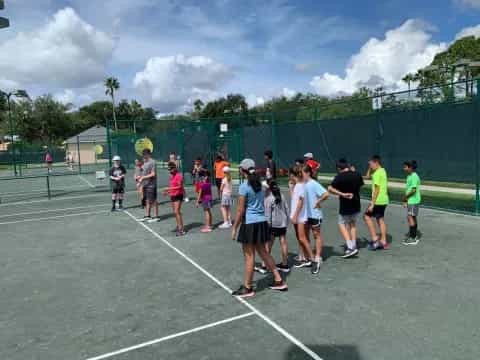 a group of people on a tennis court
