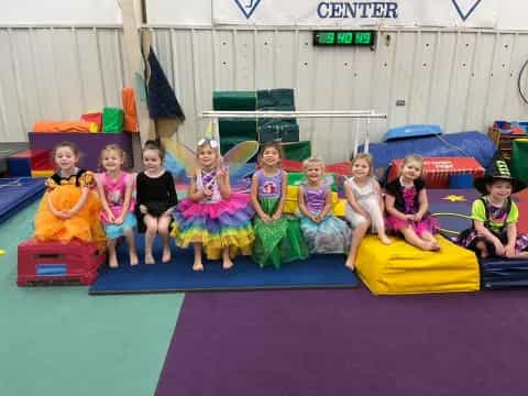 a group of children sitting on a mat posing for the camera