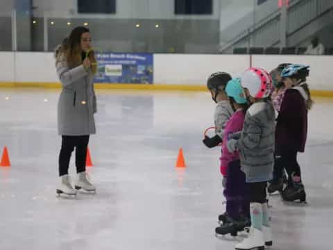 a person and a group of kids wearing ice skates