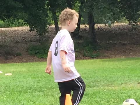 a boy playing with a football ball