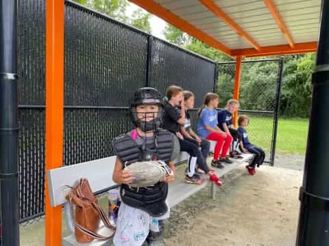 a kid in a helmet holding a baseball bat