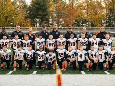 a group of people posing for a photo on a field
