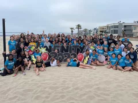 a group of people posing for a photo on a beach