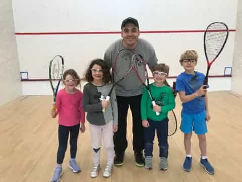 a group of kids holding tennis rackets
